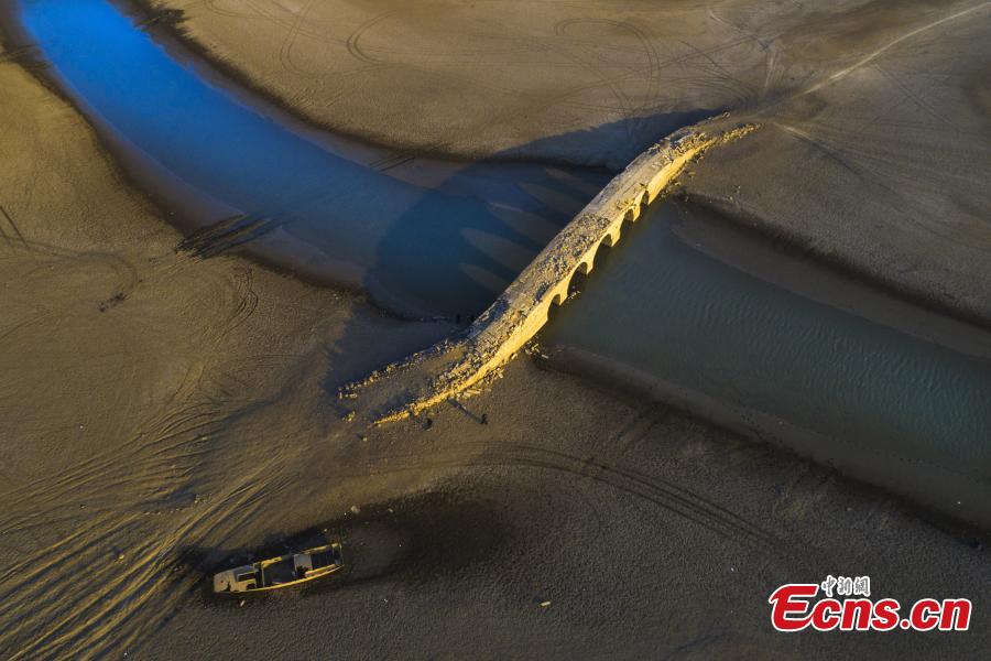 Un antiguo puente de arco de piedra emerge en el lago Poyang durante la estación seca