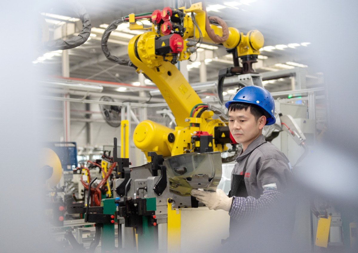 Un empleado configura un robot en una planta de autopartes en Huzhou, provincia de Zhejiang. (Foto: Tan Yunfeng/ China Daily)