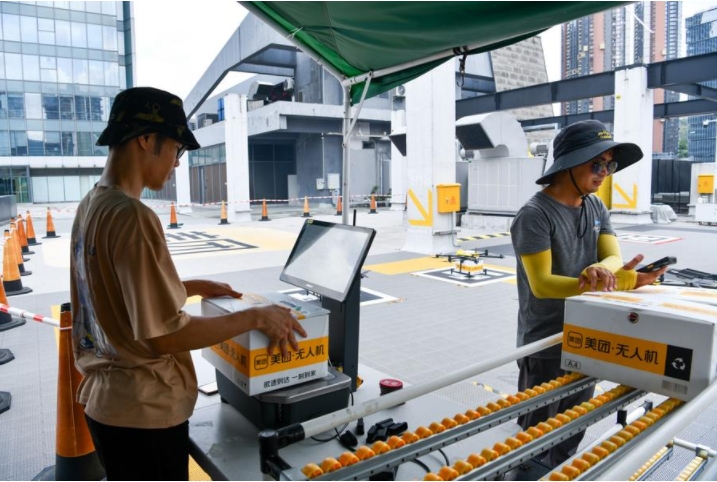 Empleados escanean cajas que contienen alimentos en un sitio de despegue de drones de entrega de alimentos no tripulados en Shenzhen, provincia de Guangdong, en el sur de China, el 15 de agosto de 2023. (Xinhua/Liang Xu)