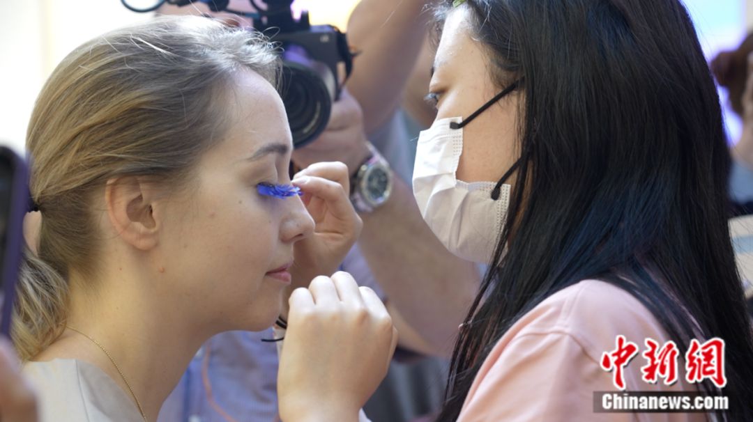 Un visitante extranjero se prueba pestañas postizas en Pingdu, una ciudad a nivel de condado en la provincia oriental china de Shandong conocida como "la capital china de las pestañas postizas". (Foto cortesía del departamento de publicidad del comité municipal de Pingdu del Partido Comunista de China)