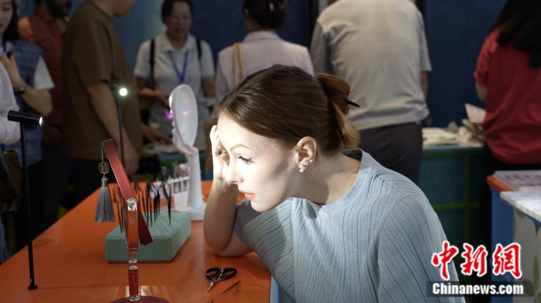 Un visitante extranjero se prueba pestañas postizas en Pingdu, una ciudad a nivel de condado en la provincia oriental china de Shandong conocida como "la capital de las pestañas postizas de China". (Foto cortesía del Departamento de Publicidad del Comité Municipal del Partido Comunista de China en Pingdu)