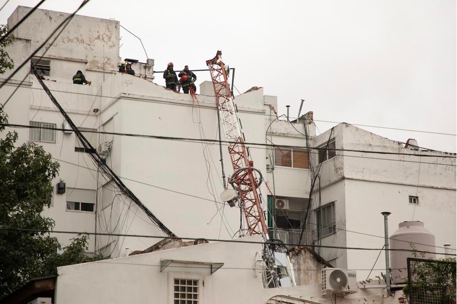 Bomberos de la Policía Federal trabajan en el sitio donde una antena de telecomunicaciones cayó sobre un edificio de departamentos durante un temporal, en la ciudad de Buenos Aires, capital de Argentina, el 11 de febrero de 2025. (Xinhua/Martín Zabala)