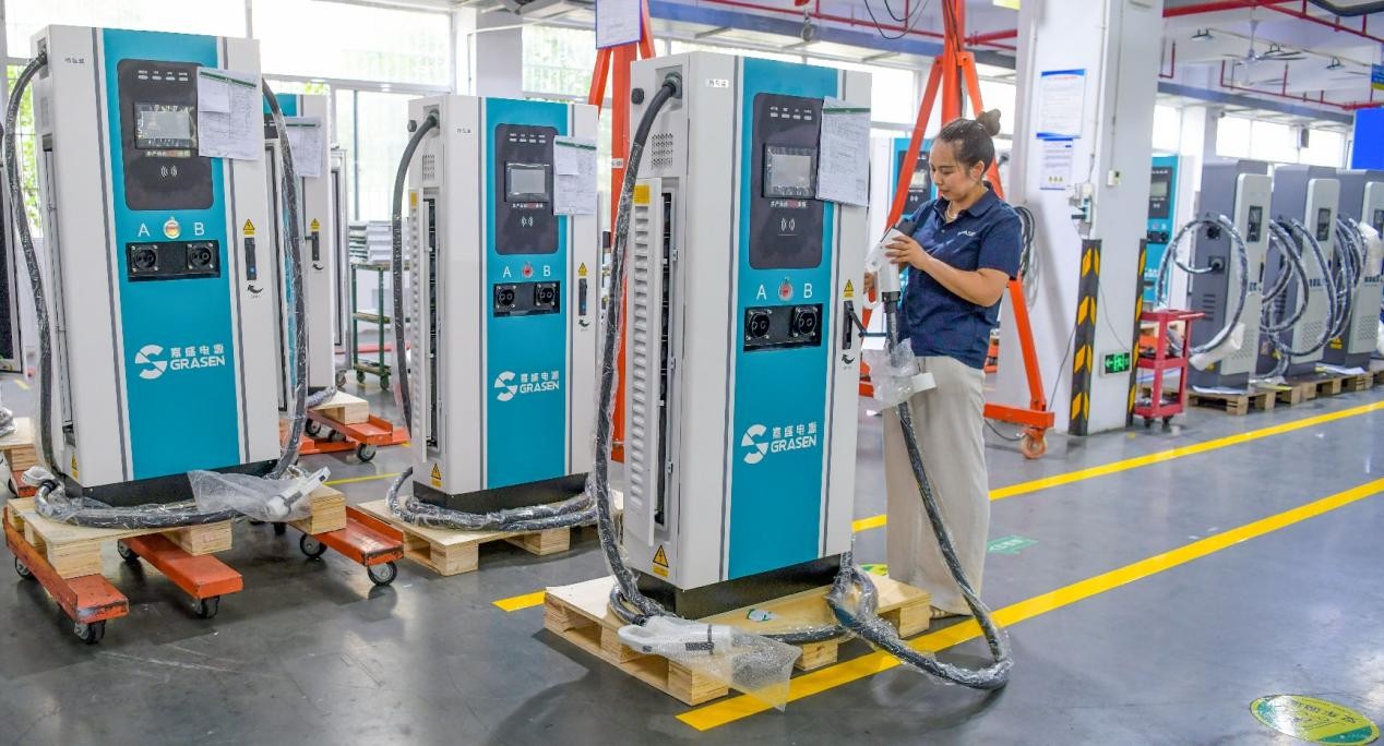 Un trabajador inspecciona puntos de carga para vehículos eléctricos en un taller de una empresa de nuevas energías en Luoyang, en la provincia de Henan, en el centro de China. (Foto: Zhang Yixi)